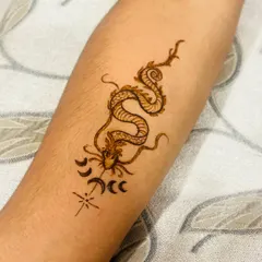 This modern dragon henna tattoo is a popular choice for guests who want something different from traditional patterns.