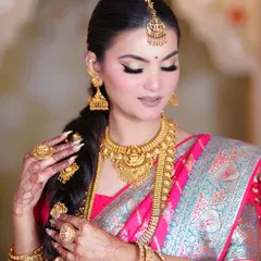 A detailed shot of the traditional braided hairstyle, adorned with gold hair accessories. This is a signature element of the South Indian bridal look.
