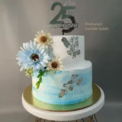 A beautiful two-tiered cake for a 25th anniversary. The silver leaf and blue watercolor effect give it a sophisticated and celebratory feel.