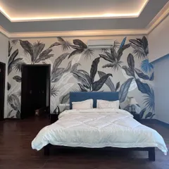 Black and white can be just as lush. This monochrome tropical mural brings a sophisticated and modern jungle vibe to a bedroom, proving that bold patterns can also be serene.