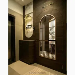 The entrance and foyer of the Sushil Advait residence, featuring an arched safety door and tropical wallpaper. We believe in making every part of the home, including the entrance, a design statement.