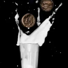 A playful and energetic photo of Oreo cookies splashing into milk against a dark background, creating a high-impact image for a snack brand.