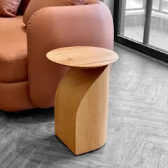 The details are where the soul of your home is found. This custom side table, with its unique curved form crafted from solid wood, adds a touch of minimal elegance next to a sofa.