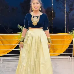 A client looking chic in a navy blue velvet crop top paired with a light gold pleated skirt. This is a great rental option for a sangeet or reception party.