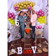 I can create elegant decor for smaller spaces too. This setup for a 6-month celebration uses gold-toned geometric stands, simple balloon clusters, and light-up letters to create a stylish photo corner.