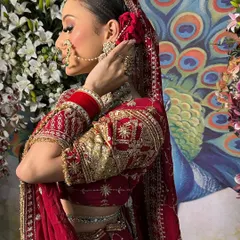 A side profile capturing the intricate embroidery on the lehenga sleeve and the elegant hairstyle with a red rose.