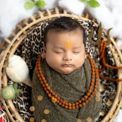 A close-up of our little Mahadev, focusing on the tripundra tilak on the forehead and the peaceful sleeping face, encircled by rudraksha beads.