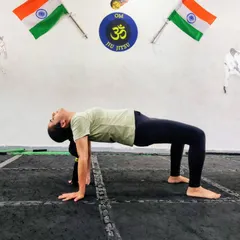 Here, a student demonstrates a bridge pose, a foundational yoga posture for strengthening the back and glutes. We focus on proper form to build a strong base.