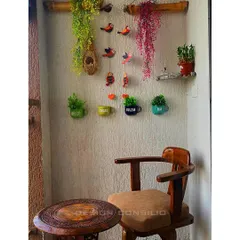 Zindagi Gulzar Hai. We created this cozy balcony corner for a client to enjoy their morning coffee. The space features a small wooden table and chair, and is decorated with hanging plants and colorful bird figurines.