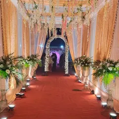 An elegant entrance passage we set up for an evening function, complete with floral arrangements, floor lighting, and hanging decorations.
