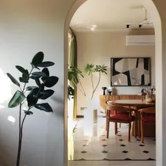 An arched doorway frames the dining area in the Jaipur House, creating an elegant transition between spaces. The interplay of light, natural materials, and curated artwork infuses the home with Jaipur's serene yet dynamic spirit.