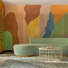 The waiting lounge features a custom curved sofa in a soft green, set against a vibrant, multi-colored mural on a perforated wooden panel. This wall cleverly conceals storage while adding a dynamic and artistic element to the room.