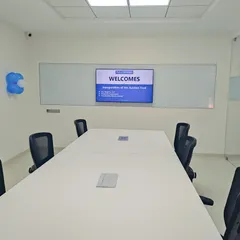 A clean, minimalist conference room at the TVS Auction Centre. The design prioritizes functionality with a large table, comfortable seating, and a wide-screen display, creating a distraction-free environment for meetings.