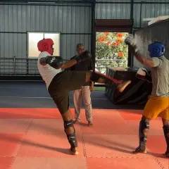 In our MMA classes, we focus on real-world skills and proper technique. Here, I am observing a sparring session, ensuring students apply what they have learned about kicks, blocks, and stances in a controlled environment.