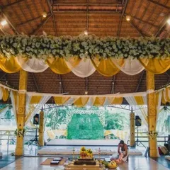 The Mahalaxmi Mantap prepared for a wedding ceremony, with a sacred havan kund at the center. The yellow and white drapes and floral arrangements create a peaceful and sattvic atmosphere, perfect for beginning a new life chapter.