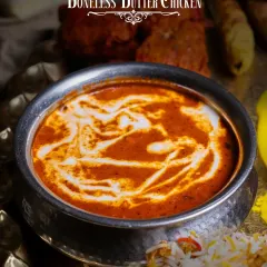A close-up of the Boneless Butter Chicken from our Akbari Thaal. Notice the rich texture and the swirl of fresh cream, a hallmark of our authentic preparation.