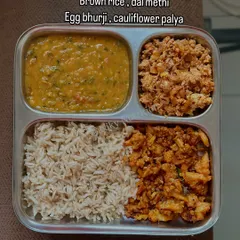 This plate features brown rice with dal methi, egg bhurji (scrambled eggs), and cauliflower palya.