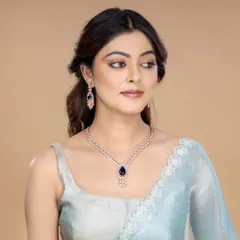 This shot features a model wearing a delicate diamond necklace with a deep blue gemstone. The soft lighting and elegant saree pairing make it ideal for showcasing fine jewellery for evening wear.