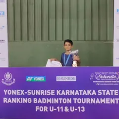 Our U-11 champion standing at the podium. We guide our young players through every step of their competitive journey, from local matches to state-level badminton tournaments.