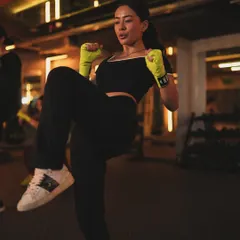 Our group classes are designed to empower you. Here, a member warms up with knee raises, getting ready for a high-energy session that combines elements of cardio and bodyweight conditioning.