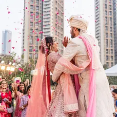 A candid and adorable moment where the bride trips slightly during the varmala, and the groom instantly has her back. It's a sweet glimpse into a future of supporting each other.