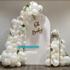 This minimalist "Oh Baby" setup shows how simple can be stunning. The all-white balloon arch, accented with gold leaves and a chic backdrop, brings a touch of modern elegance to any baby shower, perfect for intimate home celebrations.