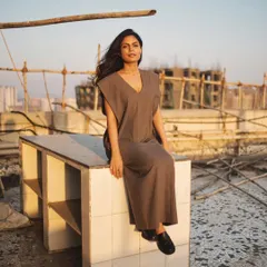 A rooftop shoot at golden hour, with the model seated against the city skyline for a serene yet urban environmental portrait.
