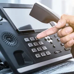 We provide modern enterprise telephony systems that form the backbone of your business communication. This close-up shows a user interacting with an IP-based phone, highlighting the intuitive interface and advanced features that streamline daily call management and internal connectivity.