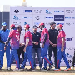 Another angle of the team handshake line in front of the sponsor wall at the cricket tournament.