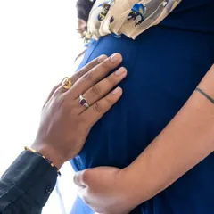 A close-up focusing on the hands on the baby bump, a simple yet powerful image of connection and anticipation.