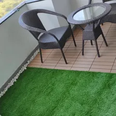 This small balcony uses a mix of materials for a clean look. I installed a section of artificial grass next to wood-look deck tiles, creating a perfect spot for a small table and chairs.