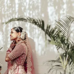 A serene side-profile of the bride. This quiet, contemplative shot highlights her elegant hairstyle and the beautiful floral arrangement in her hair.