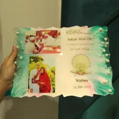 Holding the resin wedding plaque to show its size. It's a substantial piece that makes a wonderful gift for the couple.