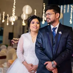 A classic portrait of the couple at their reception, with beautiful bokeh from the hanging lights creating a magical atmosphere.