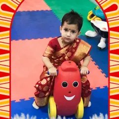 Dressed in her festive best, this little girl enjoys a ride on a smiley-faced toy in our safe, padded toddler area.