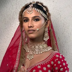 This look is one I'll forever cherish. Creating this regal, traditional bridal style on her beautiful dusky skin was pure magic. The rich red lehenga and kohl-rimmed eyes come together for a powerful and timeless statement.