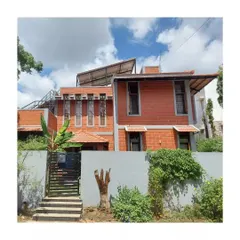The exterior of this home in Secunderabad showcases exposed brick, prominent jaali windows, and rooftop solar panels, demonstrating a commitment to both aesthetics and energy efficiency.