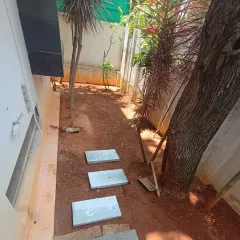 The ground has been cleared, and I've started laying out the first few stepping stones to plan the new walkway.