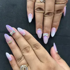 This photo displays the full set of iridescent ombre nails with rhinestone bows and accents. The combination of the chrome finish and sparkling gems creates a stunning, multi-dimensional effect.