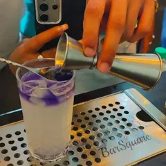 Layering is an art form. A close-up shot of a student carefully pouring to create a distinct, beautiful layer in a cocktail, a skill we teach in our advanced course.