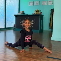 The proud smile of accomplishment. This student nails her center split, showcasing the results of her consistent effort and our structured flexibility training.