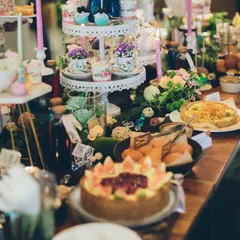 A full view of the whimsical brunch setup. The dessert and food table was a feast for the eyes, laden with themed treats, floral arrangements, and charmingly mismatched crockery to capture the delightful chaos of a mad tea party.
