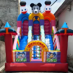 A front view of our 12x18 foot 3-slider bouncy castle. This model features a central climbing ladder and three slides, all made with high-quality, brightly colored SRF fabric.