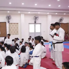 Students listening intently during a seminar. Learning is not just physical; it's about absorbing knowledge from experienced masters.
