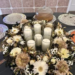 A beautiful floral wreath centerpiece designed for a dinner party table. I surrounded glass hurricane vases and candles with a mix of white and gold-dusted chrysanthemums and daisies.