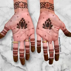 This minimal design features a single, bold lotus motif in the center of the palm, complemented by a floral wristband. The fingers are adorned with simple bands, making it a clean and sophisticated choice for any party.