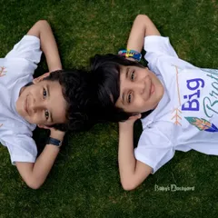 Big brother and little brother, side by side. This sweet overhead shot with their matching shirts is a wonderful way to capture the bond between siblings.