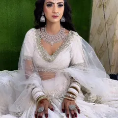 A full-length view of a stunning white lehenga paired with a sparkling American Diamond necklace set, available for rent.