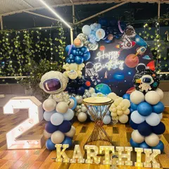 3, 2, 1, blast off! This space-themed setup for Karthik's 2nd birthday was an interstellar adventure. I used a galaxy backdrop, astronaut and rocket cutouts, planet-themed balloons, and light-up letters to create a party that was out of this world.