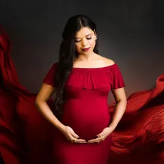 The beauty of a mother-to-be is timeless. In this classic maternity portrait, I use flowing red fabric against a dark, moody background to create a sense of drama and elegance, drawing all the attention to you and your bump.